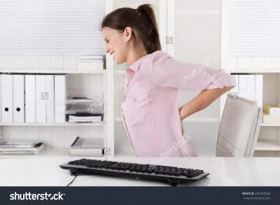 stock photo young woman sitting with backache in the office